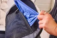 A person removes a storage bag from the Yeti Panga 28L Waterproof Backpack