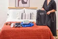 A person zips up the Yeti Panga 28L Waterproof Backpack