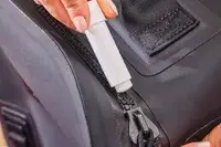 A person uses the Yeti Zipper Lubricant on the Yeti Panga 28L Waterproof Backpack