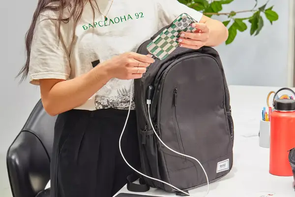 Person using the Solo Re:Define Backpack to charge their phone