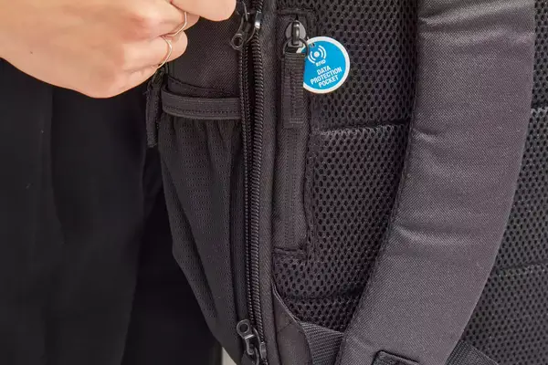 Hand unzipping the side of the Solo Re:Define Backpack