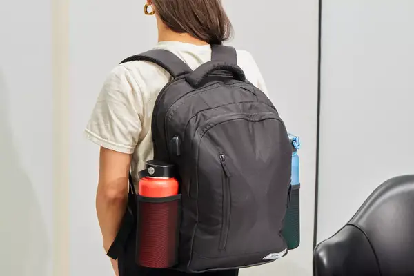 Person wearing the Solo Re:Define Backpack with water bottles in each side pocket