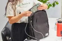 Person using the Solo Re:Define Backpack to charge their phone