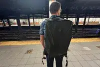 Man wearing the Tortuga Travel Backpack 40L while standing on a subway platform