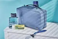 A person holding the Ostrich Pillow Go Neck Pillow on their neck