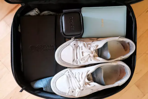 The EPICKA Universal Travel Adapter packed in a case with shoes and other items