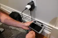 A hand holding a device plugged into the EPICKA Universal Travel Adapter