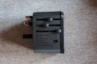 The side view of the EPICKA Universal Travel Adapter on a gray fabric background