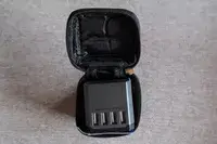 The EPICKA Universal Travel Adapter inside of its travel case on gray fabric