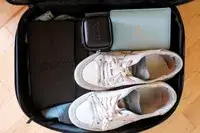 The EPICKA Universal Travel Adapter packed in a case with shoes and other items