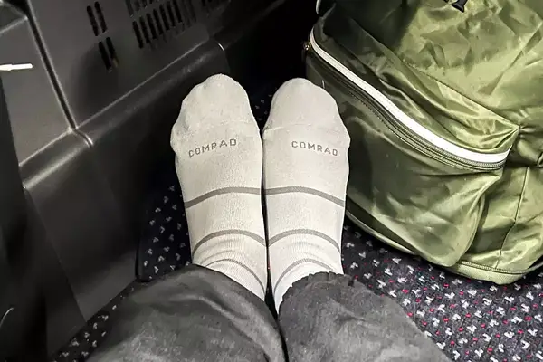 Comrad Knee High Compression Socks On Persons Feet With Green Backpack