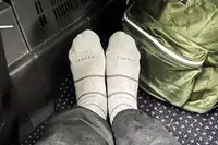 Comrad Knee High Compression Socks On Persons Feet With Green Backpack