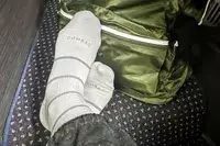 Comrad Knee High Compression Socks On Persons Feet With Green Backpack