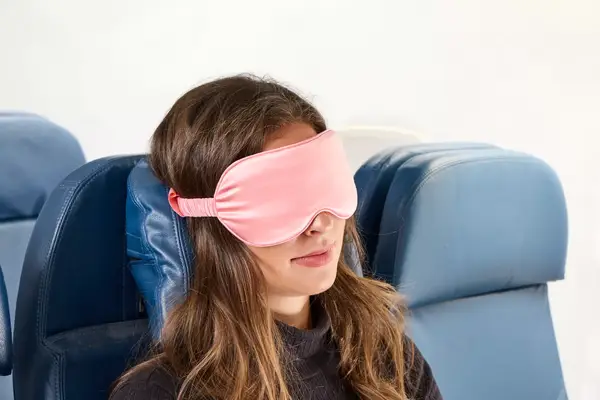 A person wearing the Slip Lovely Lashes Contour Sleep Mask on a plane