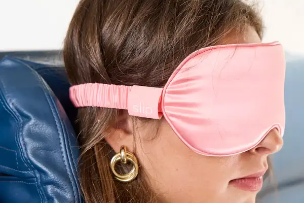 Close up of the side of a person wearing the Slip Lovely Lashes Contour Sleep Mask on a plane
