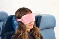 A person wearing the Slip Lovely Lashes Contour Sleep Mask on a plane
