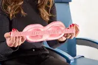 A person stretching the strap on the Slip Lovely Lashes Contour Sleep Mask in an airplane