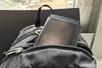The Quince Nappa Leather RFID Blocking Passport Holder inside a zippered backpack