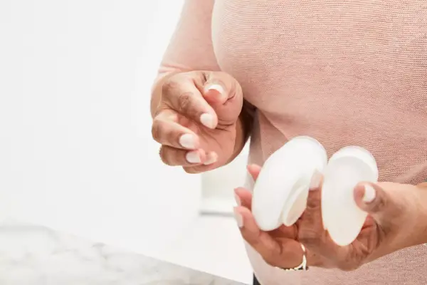 Person holding Liquisnugs Premium Leak-Proof Silicone Travel Bottles over counter