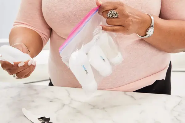 Person holding ziplock bag with Liquisnugs Premium Leak-Proof Silicone Travel Bottles