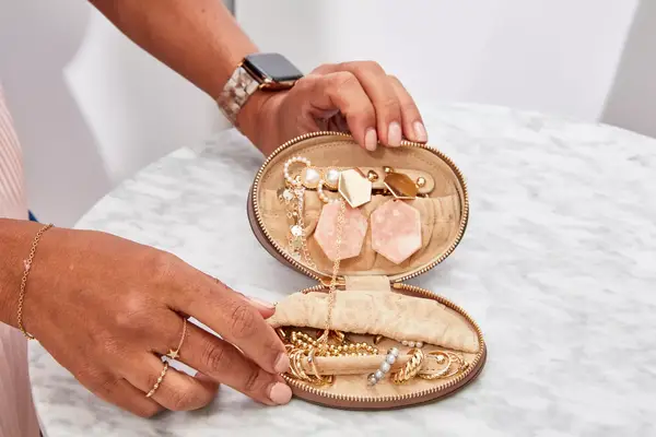 Hands holding an opened Cuyana Travel Jewelry Case