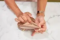 Hands holding an opened Cuyana Travel Jewelry Case