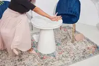 A woman shoves the Cuyana Travel Jewelry Case off of a table during testing