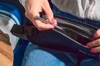 Hand placing a pen in the Raytix RFID Money Belt