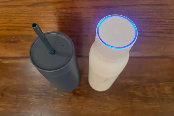 A Larq Bottle PureVis next to a gray travel cup