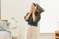 A person dancing in a bedroom setting while wearing the Bowers & Wilkins Px7 S2e 