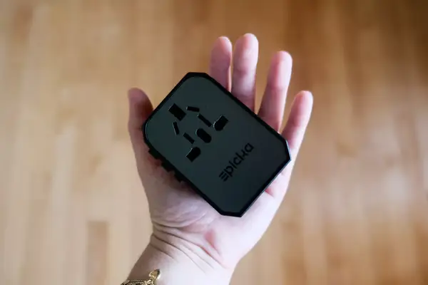 A hand holding the EPICKA Universal Travel Adapter