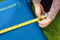 A person measures the Therm-a-Rest BaseCamp Sleeping Pad