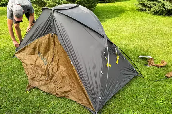 A person assembles the Kuiu Mountain Star 2 Person Tent