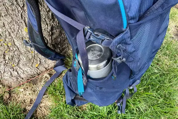 The nCamp CafÃ© Portable Coffee Maker in the cup holder of a hiking pack