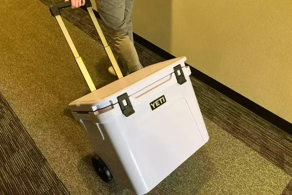 a person rolling Yeti Roadie 60 Wheeled Cooler