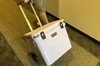 a person rolling Yeti Roadie 60 Wheeled Cooler