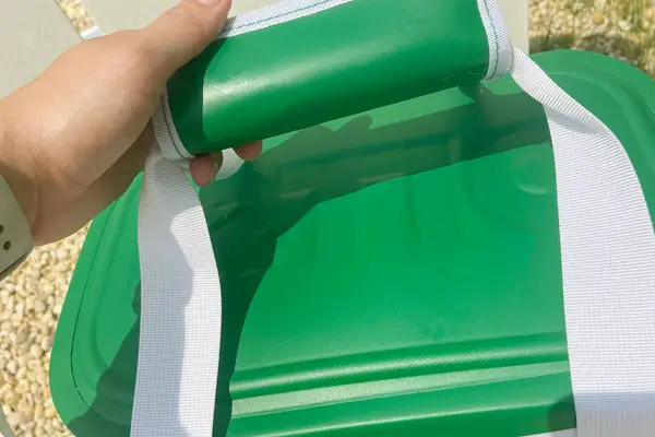 A hand holds the handle of the RTIC Insulated Soft Cooler Bag