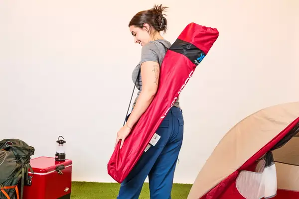 Someone wearing the Kijaro Dual Lock Camping Chair pouch on their shoulder