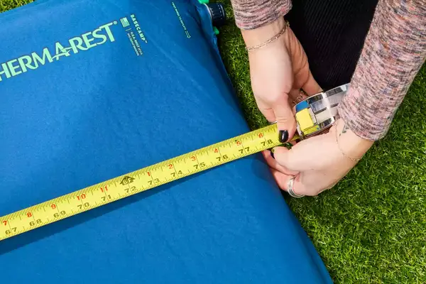 A person measures the Therm-a-Rest BaseCamp Sleeping Pad