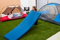 A person inflates the Therm-a-Rest BaseCamp Sleeping Pad by mouth