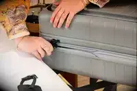 A person closes the Monos Expandable Carry-on Pro