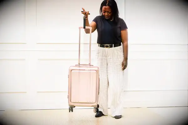 A person weighs the Calpak Ambeur Carry-On