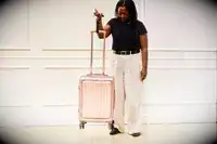 A person weighs the Calpak Ambeur Carry-On