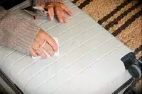 A person cleans a mark off of the Away The Front Pocket Bigger Carry-On