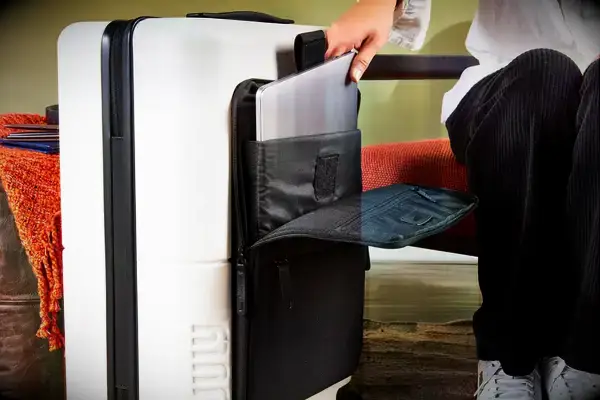 A person places a laptop into the sleeve on a July Carry On Pro SnapSleeve
