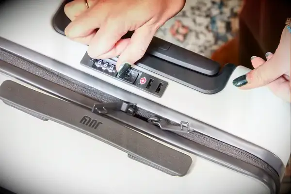 Hand touching the lock on a July Carry On Pro SnapSleeve