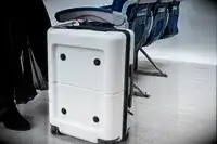 Person standing near July Carry On Pro SnapSleeve alongside airplane seats