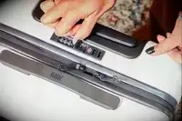 Hand touching the lock on a July Carry On Pro SnapSleeve