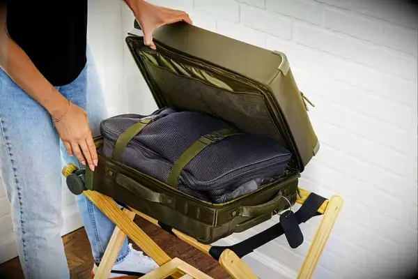 A person opening a packed Dagne Doverr Seattle Carry On Rolling Luggage 20.5