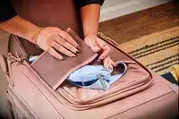 A person secures a waist pack in the Dagne Dover Smaller Seattle Carry-on Luggage 20.5 Inches